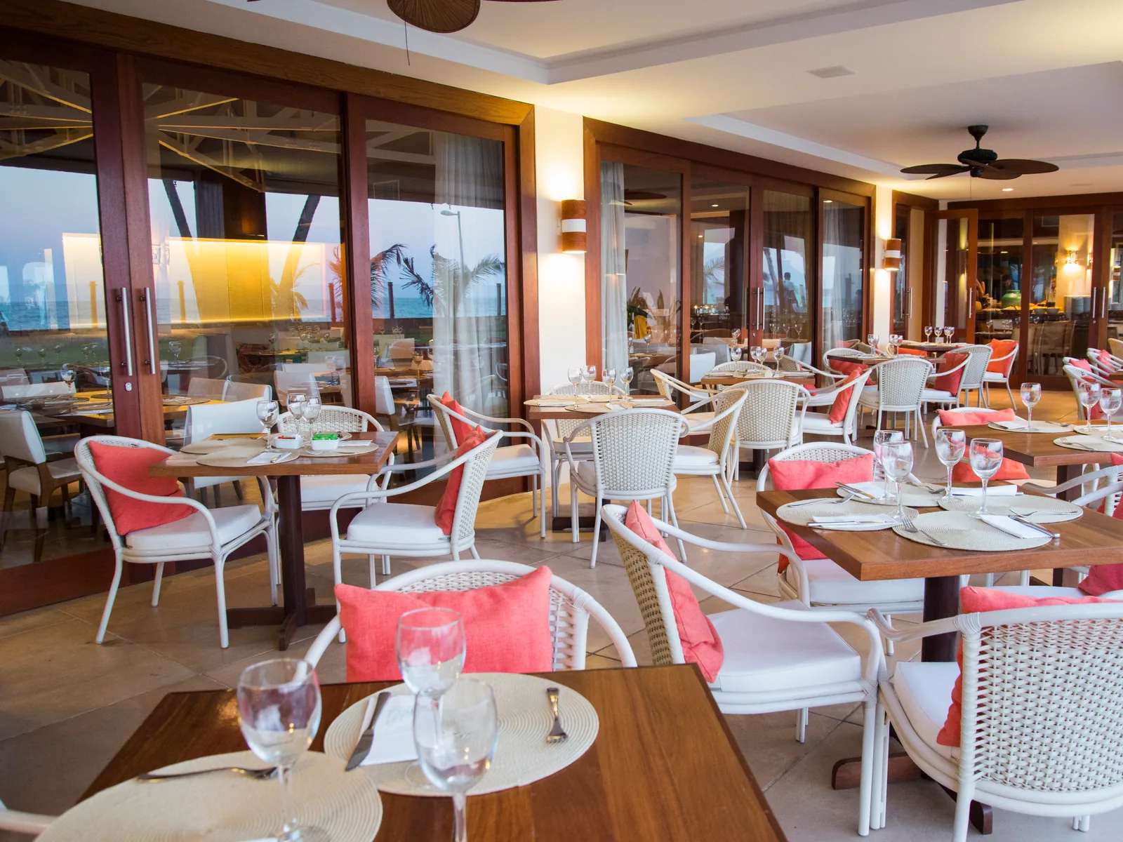 Canoas restaurant dining room set for dinner, with tables laid and warm lighting